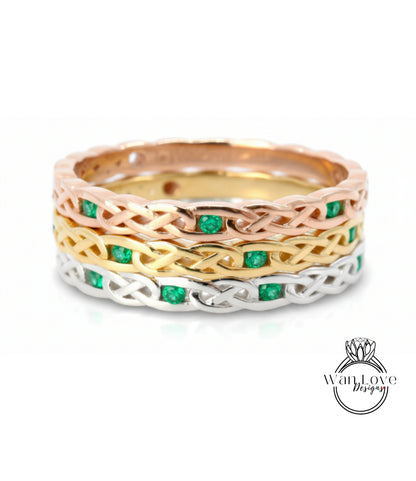 A ring with a Celtic knot design and green gemstones.