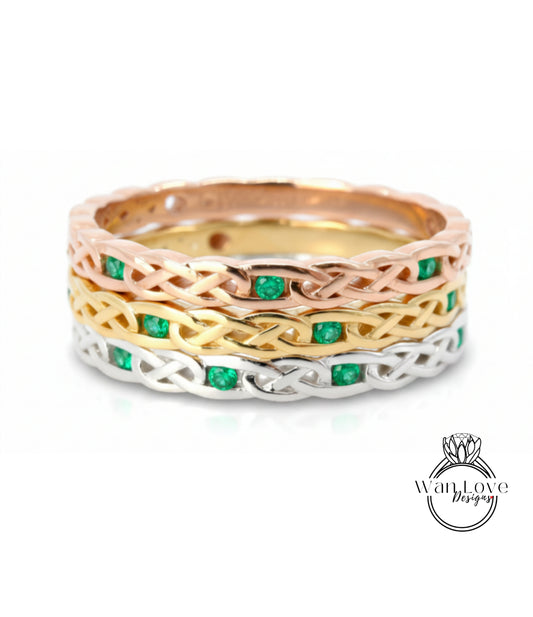 A ring with a Celtic knot design and green gemstones.