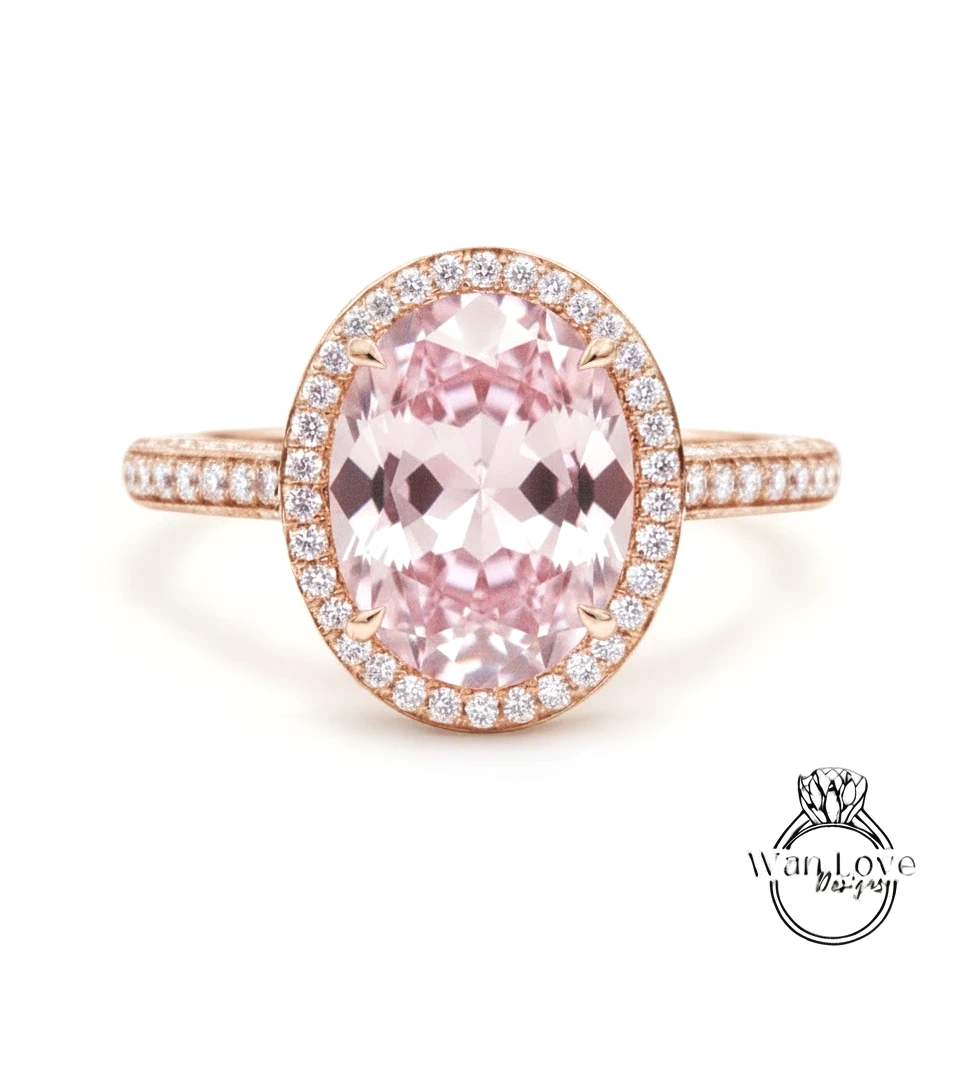 A beautiful pink gemstone ring with a halo of smaller diamonds around the center stone.