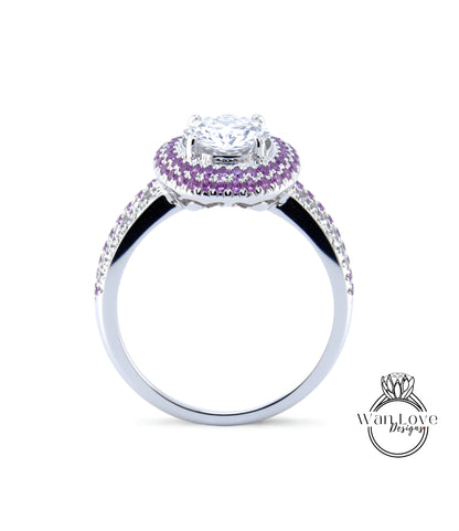 A silver ring with a large central diamond surrounded by a halo of smaller diamonds and purple gemstones.