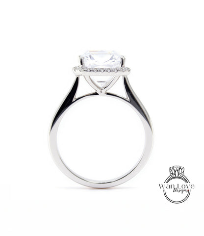 A silver engagement ring with a large, clear gemstone set in the center, surrounded by a halo of smaller diamonds.