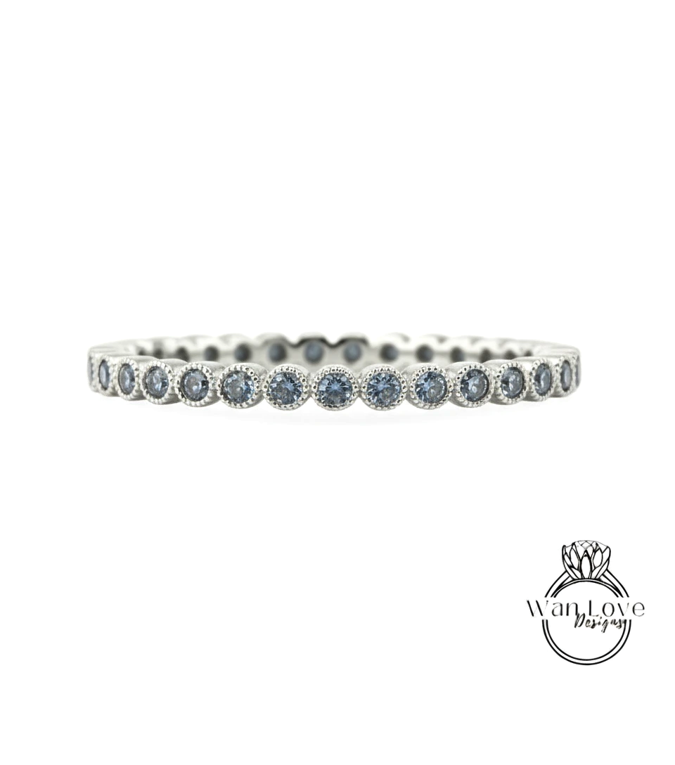 A silver band ring with blue gemstones set in a row.