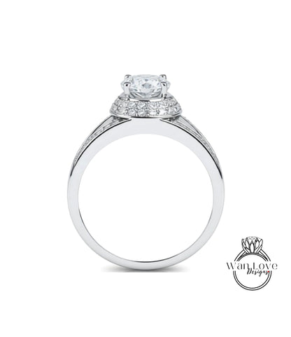 A silver engagement ring with a large central diamond surrounded by smaller diamonds on the band.