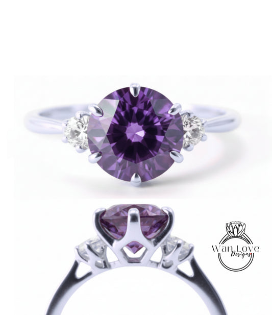 a silver ring with a large purple gemstone, likely a diamond, set in the center. The ring has a unique design with three smaller diamonds on either side of the large purple gemstone.