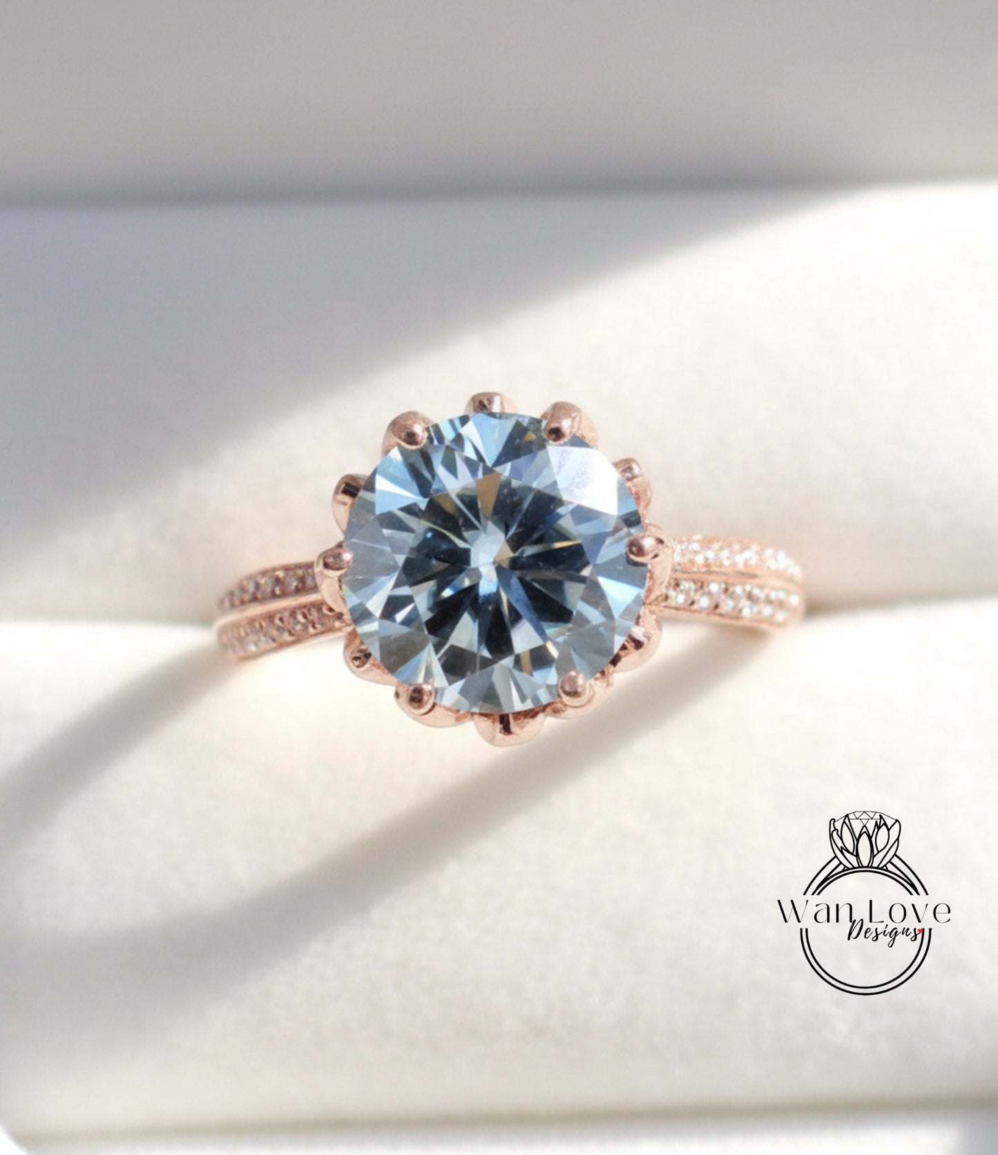 A close-up image of a large, round blue gemstone set in a rose gold ring.