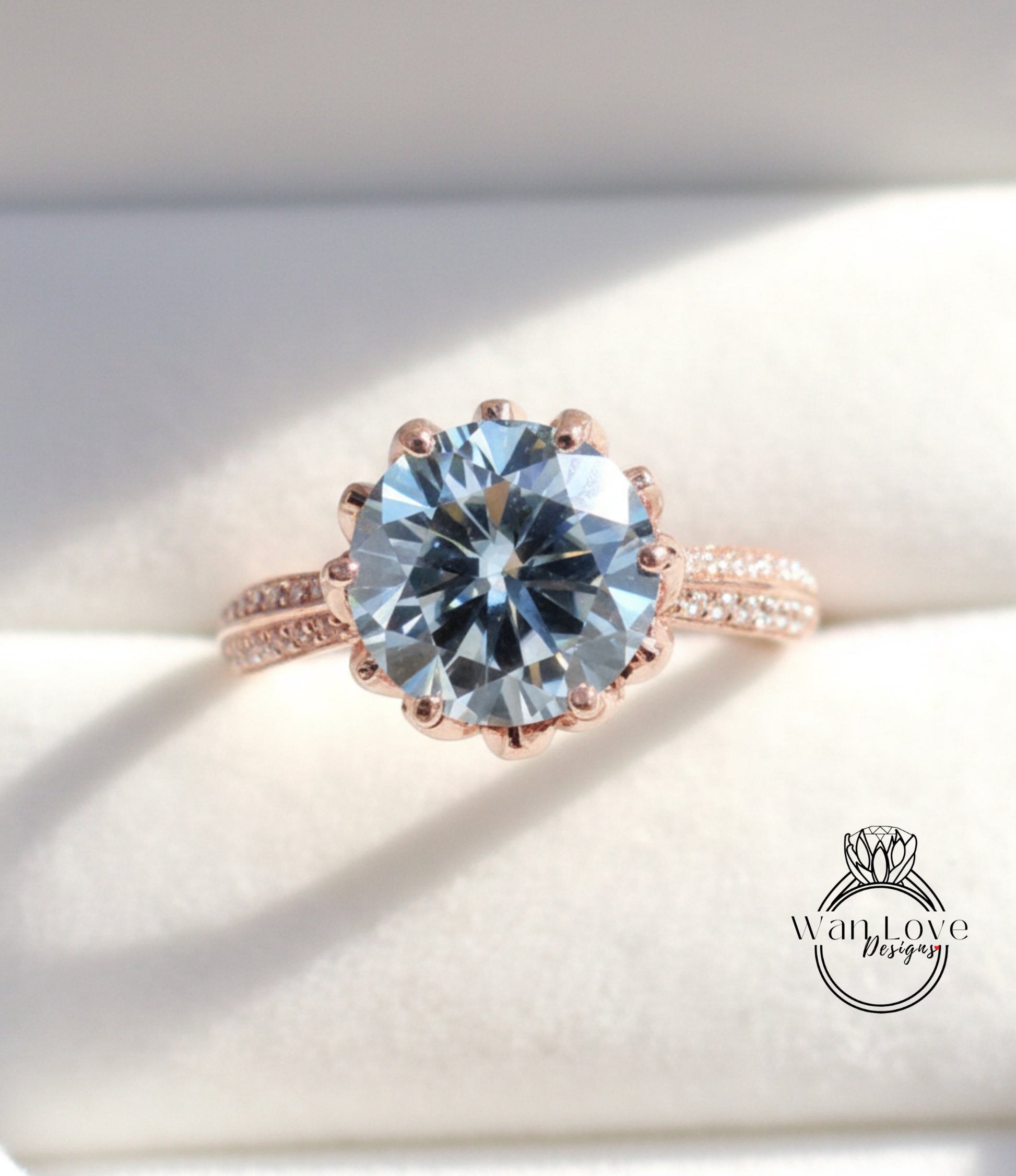 A close-up image of a large, round blue gemstone set in a rose gold ring.