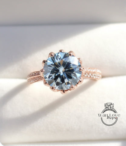 A close-up image of a large, round blue gemstone set in a rose gold ring.