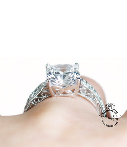 A close-up view of a diamond engagement ring on a person's hand, showcasing the intricate design and sparkling gemstone.