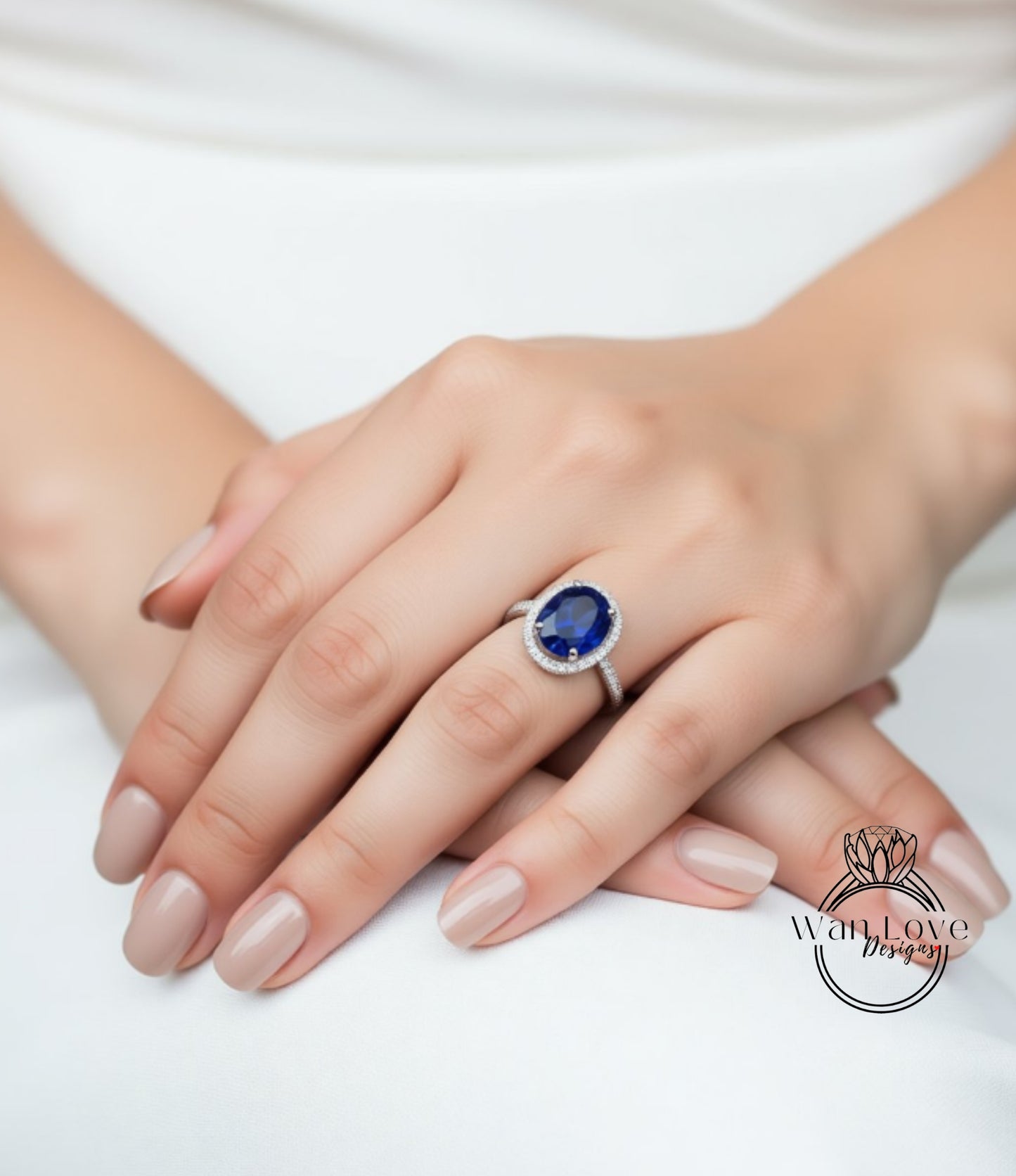 A close-up of a person's hand wearing a ring with a large blue gemstone.