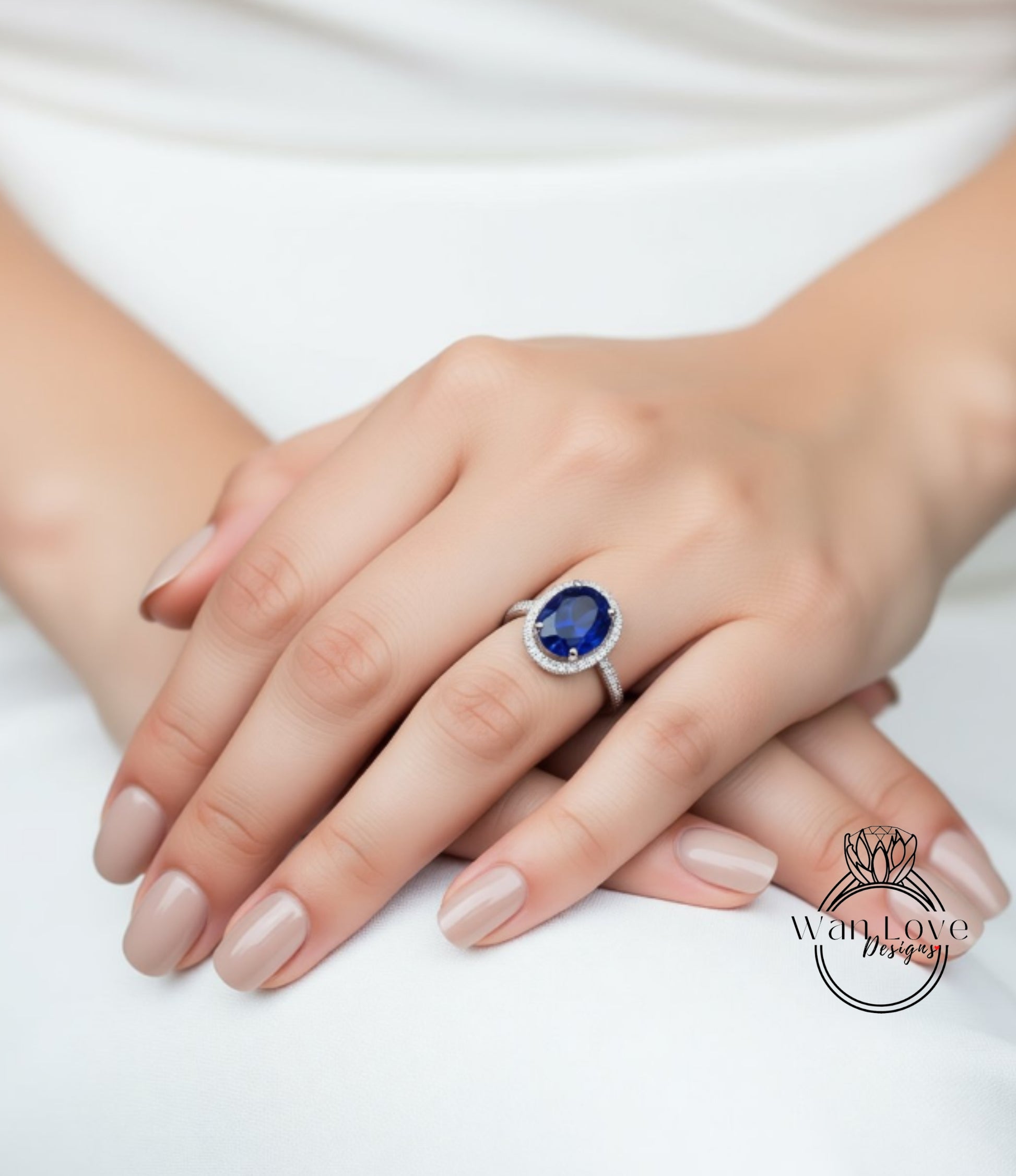 A close-up of a person's hand wearing a ring with a large blue gemstone.