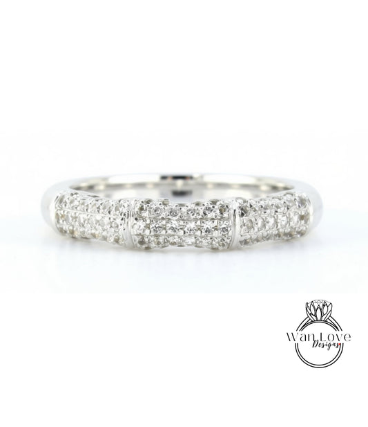 A silver ring with a row of small diamonds set in it.