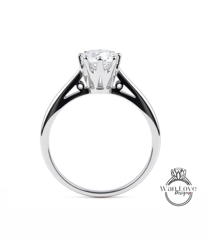 A silver engagement ring with a large central diamond and a smaller diamond on either side.