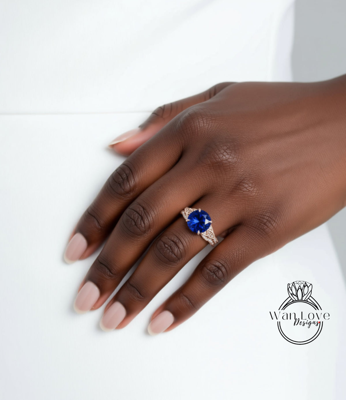 A close-up of a hand wearing a large blue gemstone ring on the ring finger.