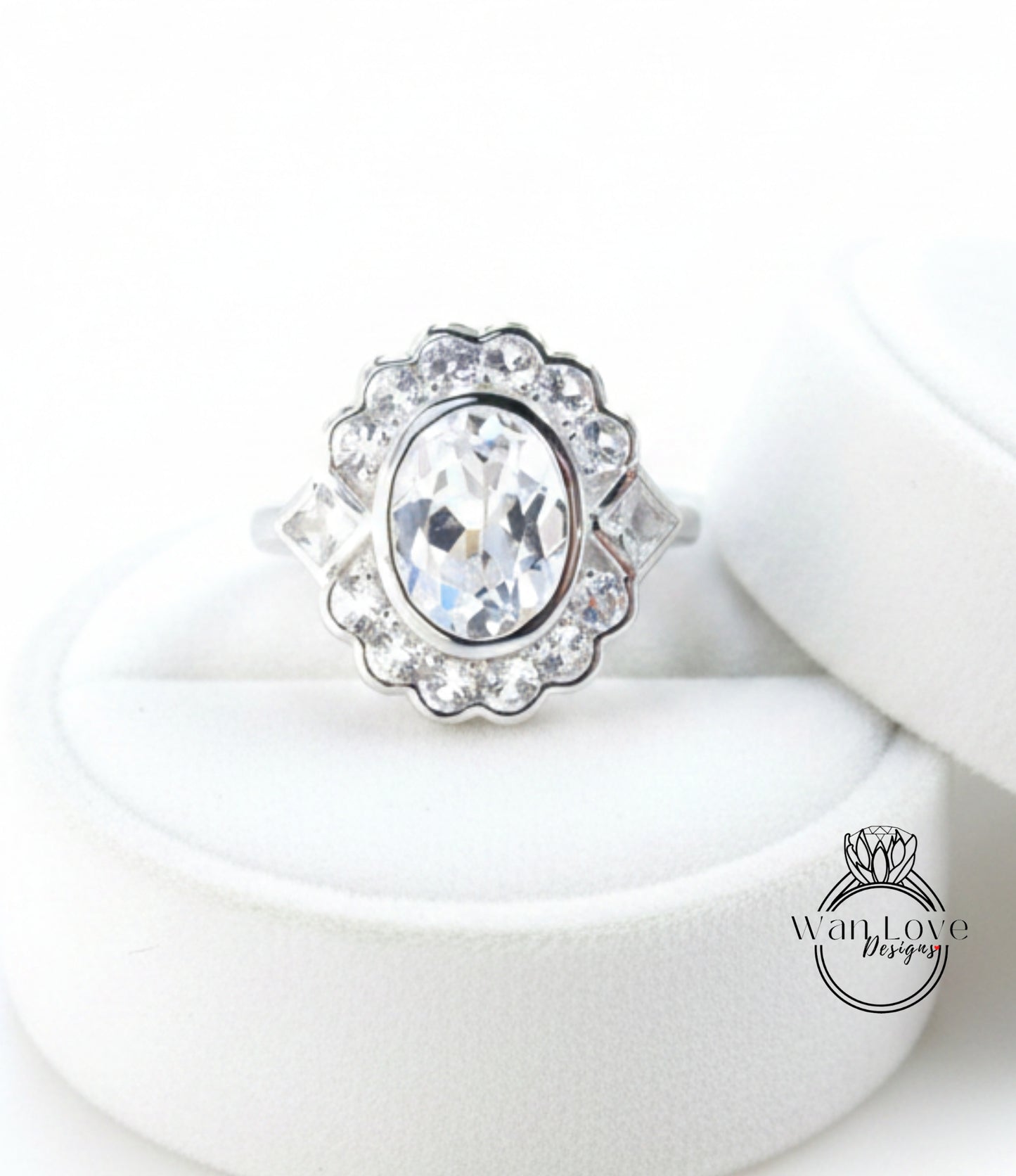 A close-up view of a diamond ring with a large central diamond surrounded by smaller diamonds, placed on a white circular stand.