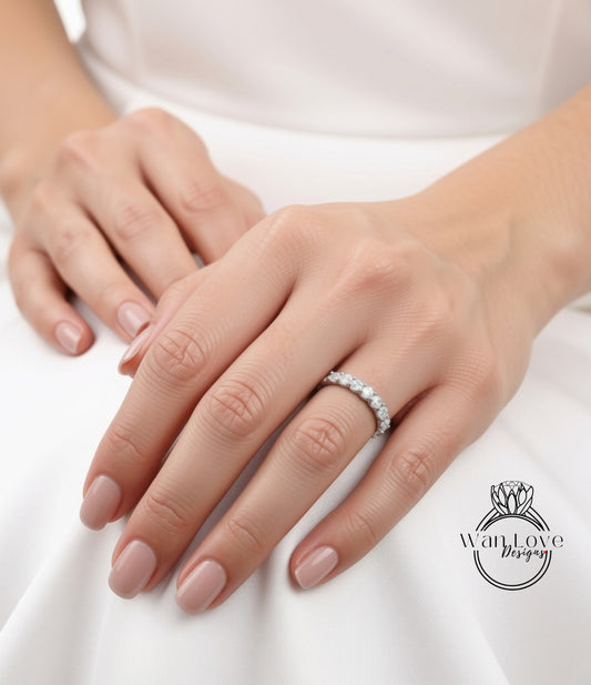 A close-up of a person's hands wearing a diamond ring on the ring finger.