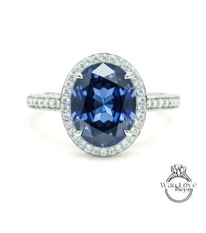 A stunning blue gemstone ring with a halo of sparkling diamonds around the center stone.