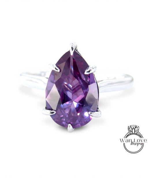 A ring with a large, deep purple gemstone, possibly a diamond, set in a silver band.