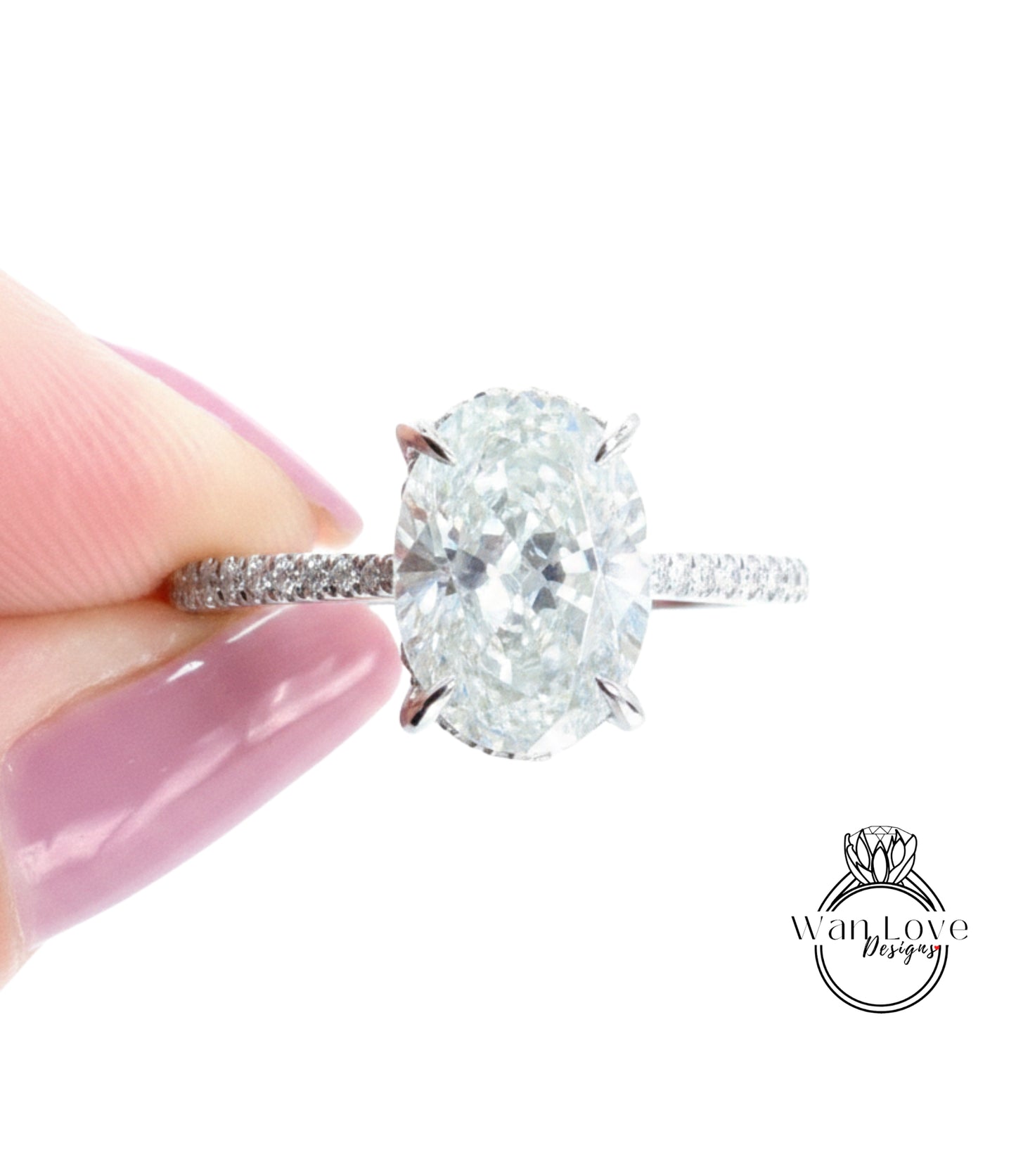 A close-up of a diamond engagement ring being held by a person's hand, showcasing the large oval-shaped diamond set in a silver band with smaller diamonds.