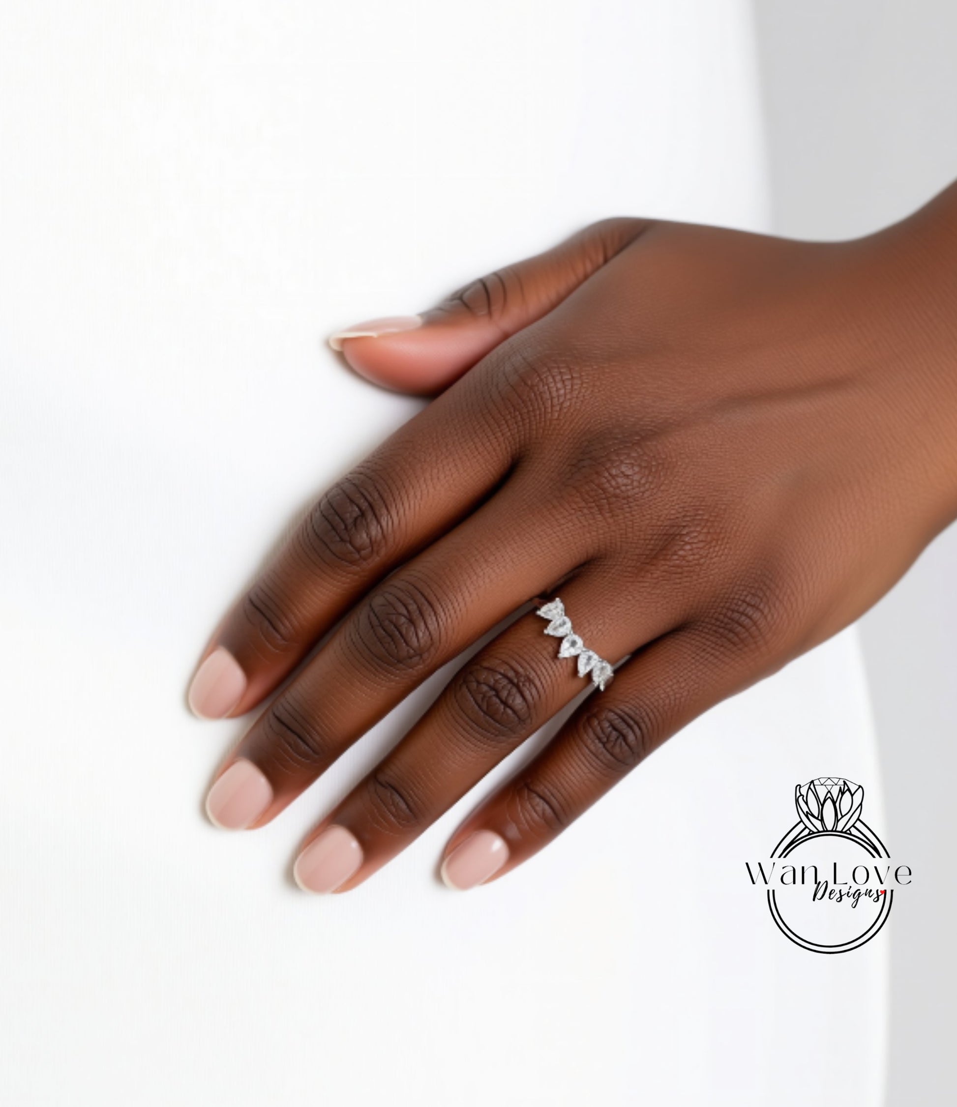 A close-up of a hand wearing a diamond ring on the ring finger.