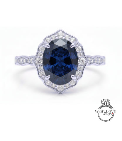 A close-up of a silver ring with a large oval-shaped blue gemstone at the center, surrounded by smaller diamonds.