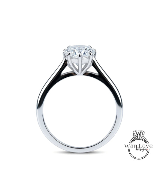 A silver engagement ring with a large central diamond and a smaller diamond on either side.