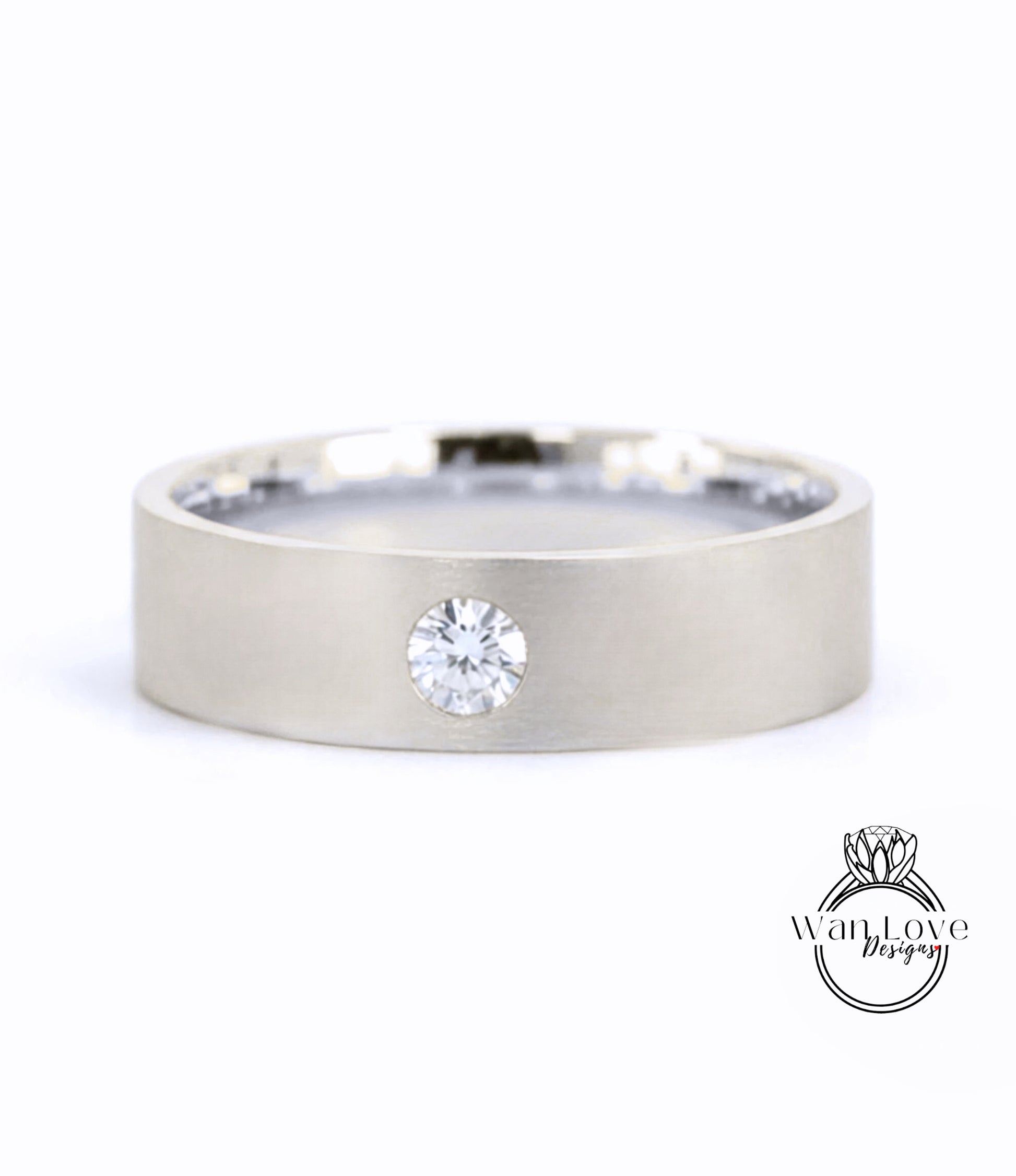 A silver-colored ring with a large diamond set in the center.