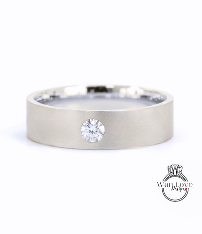 A silver-colored ring with a large diamond set in the center.