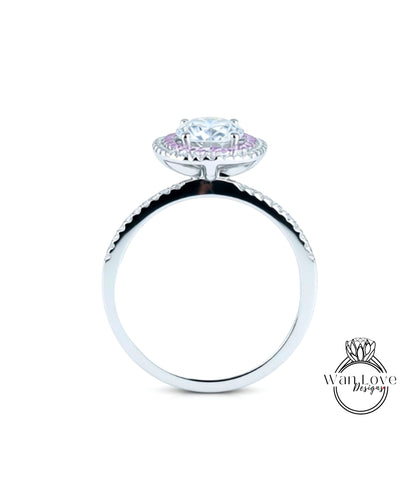 A silver ring with a large, round diamond at the center, surrounded by smaller diamonds.