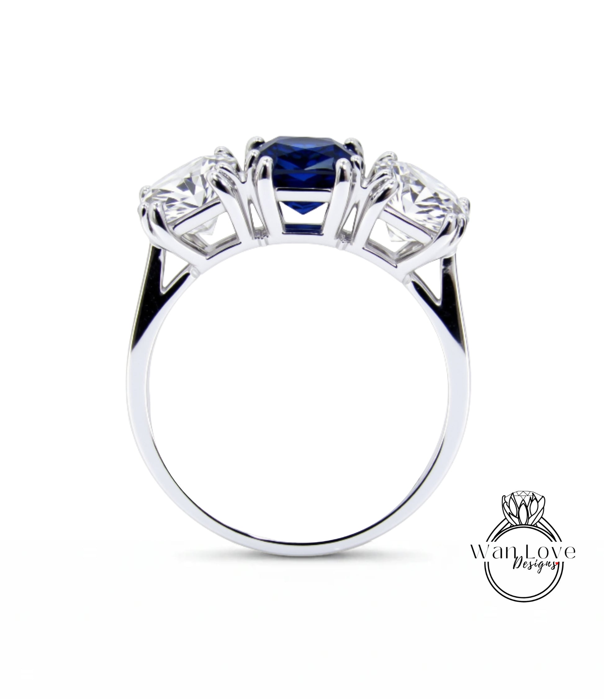 A silver ring with three gemstones, including a blue gemstone, set in a three-prong design.