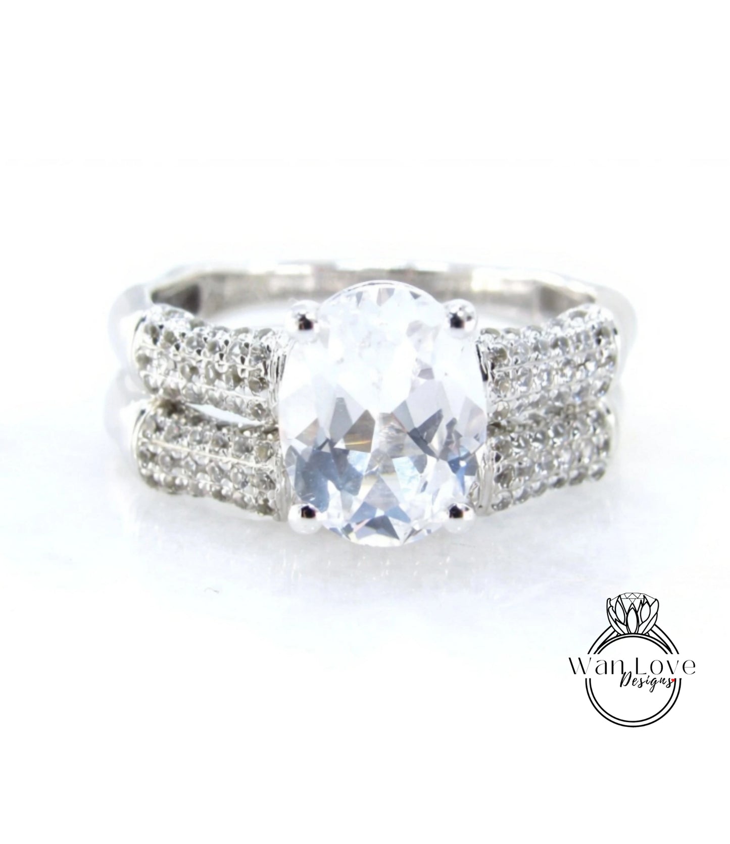 A close-up view of a diamond engagement ring with a large, clear gemstone set in a silver band adorned with small diamonds.