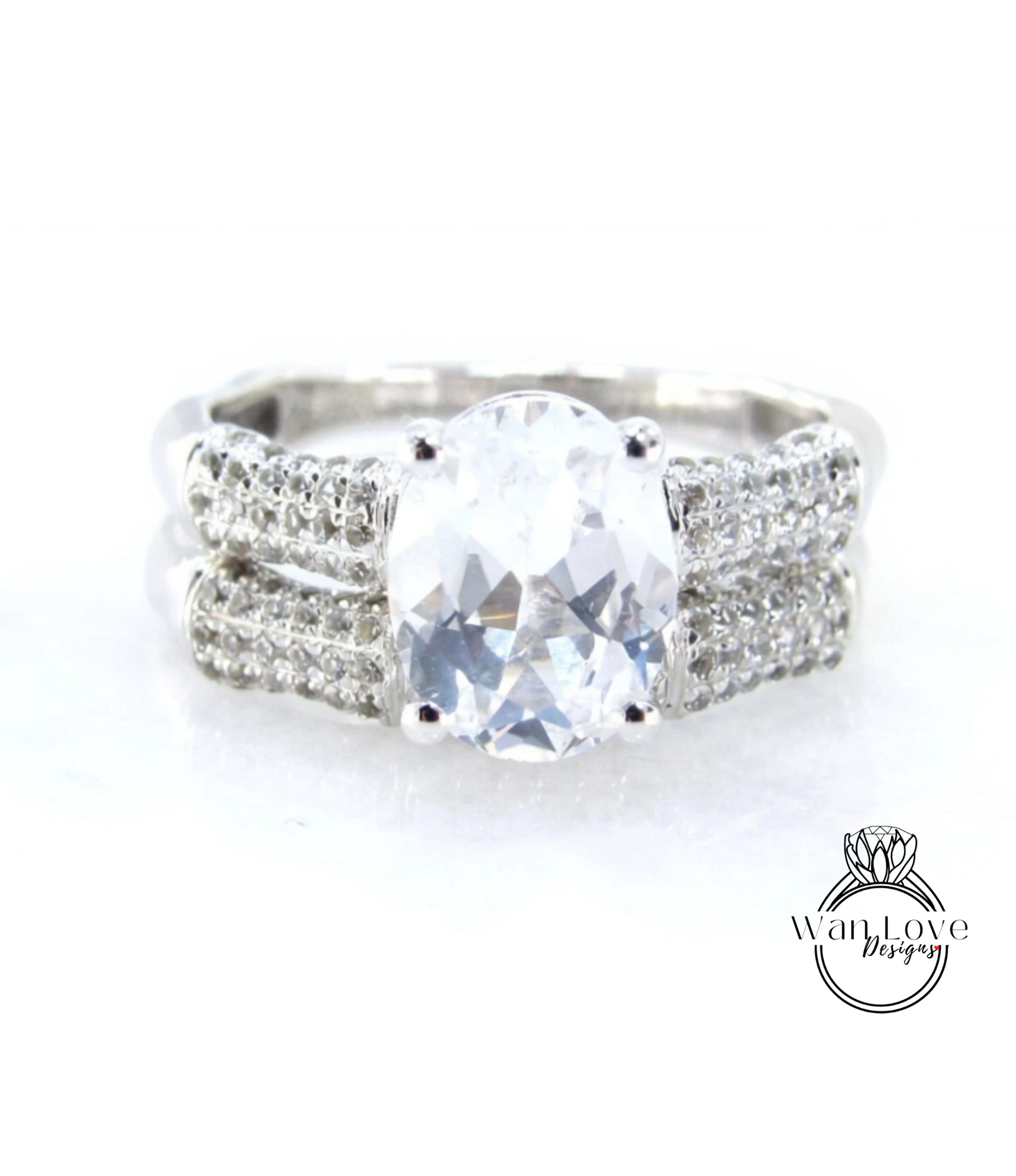 A close-up view of a diamond engagement ring with a large, clear gemstone set in a silver band adorned with small diamonds.