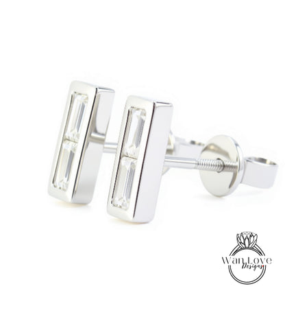 A pair of silver earrings with rectangular cut gemstones.