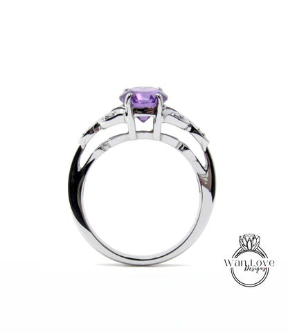 A silver ring with a purple gemstone, possibly a sapphire, set in a halo-like design.