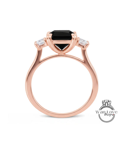 A rose gold ring with a large black gemstone set in the center, surrounded by smaller diamonds.