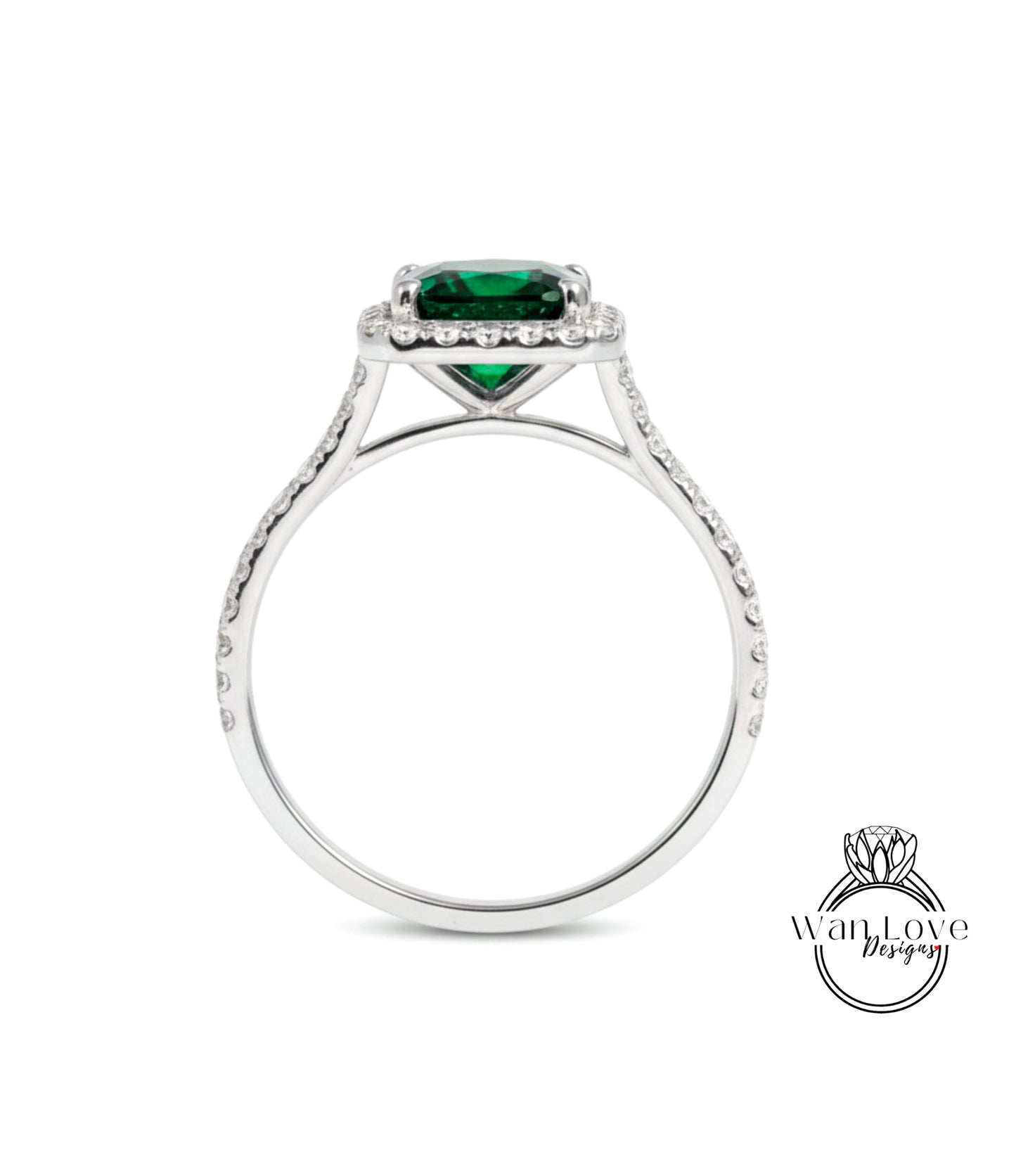 A silver ring with a large green gemstone, likely a diamond, set in the center.