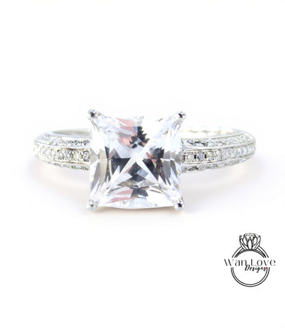 A close-up view of a diamond engagement ring with a large, clear gemstone set in a silver band.