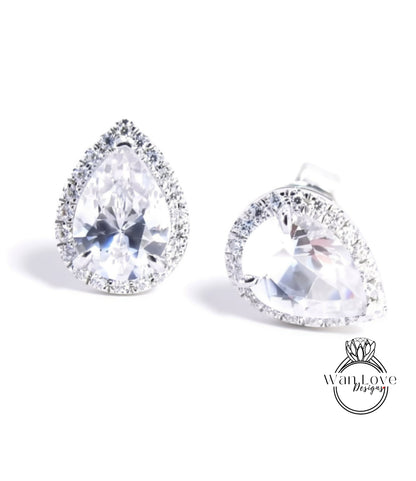 A pair of elegant earrings with large, clear gemstones set in a halo of smaller diamonds.