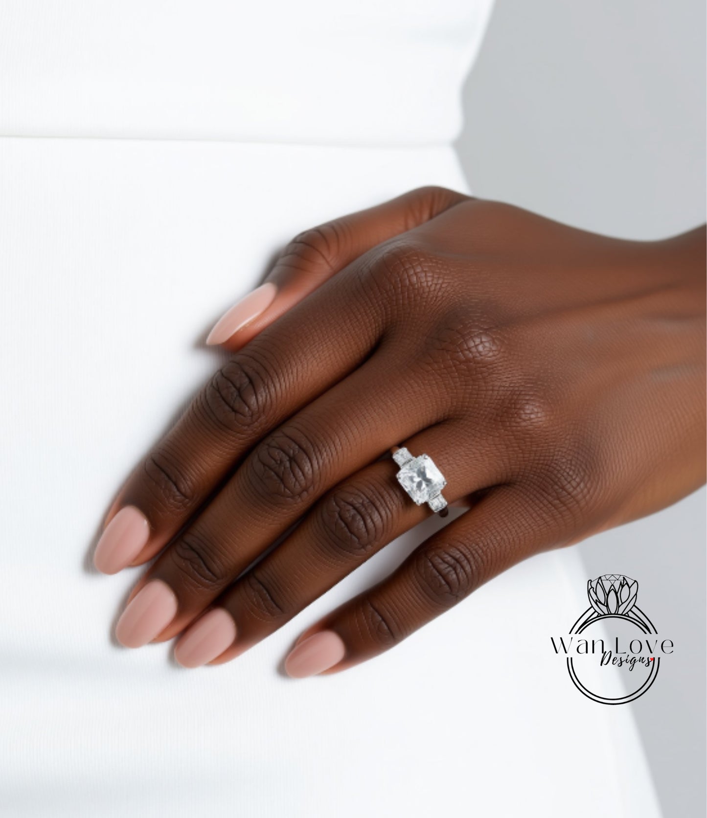 A close-up of a hand wearing a diamond engagement ring.
