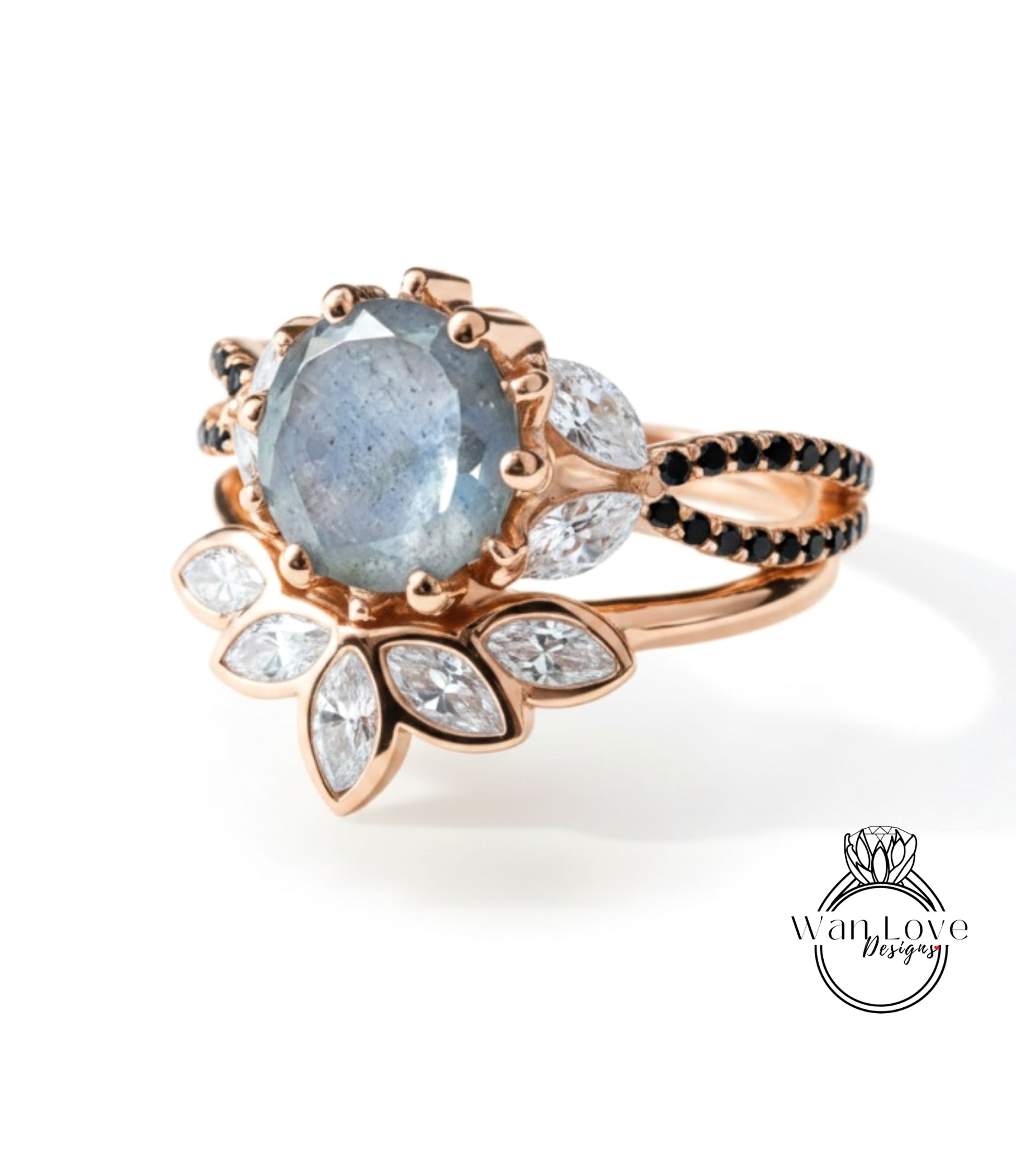 A rose gold ring with a large blue gemstone and smaller white and black gemstones set in a floral design.