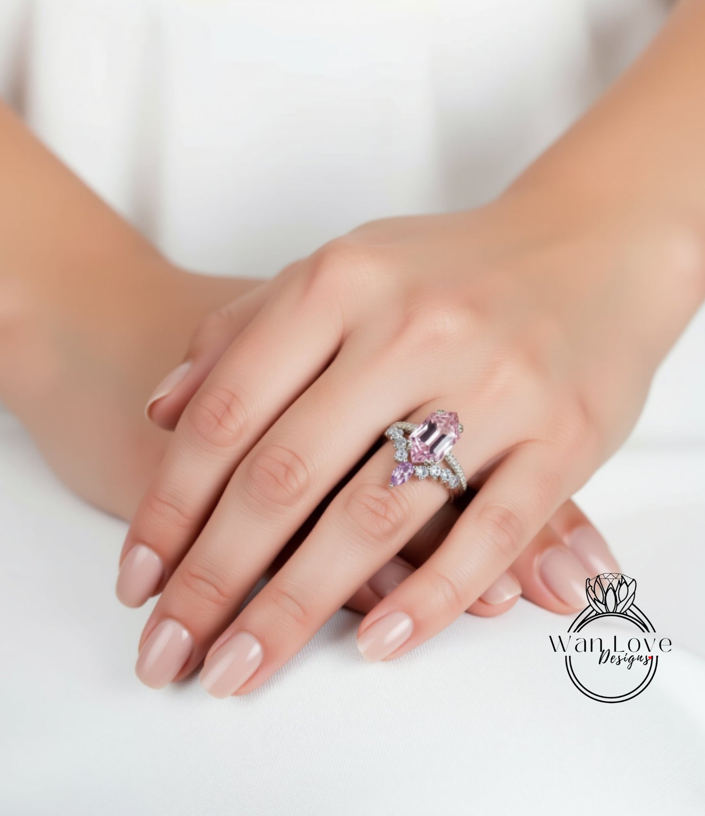 A close-up of a person's hand wearing a ring with a pink gemstone.