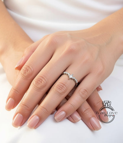 A close-up image of a person's hands wearing a diamond engagement ring.