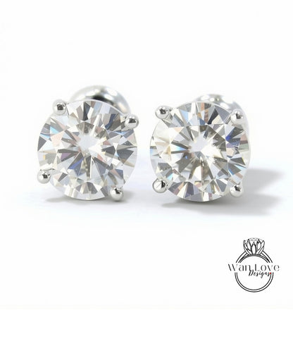 A pair of elegant diamond earrings with a large, brilliant-cut diamond set in a silver metal frame.