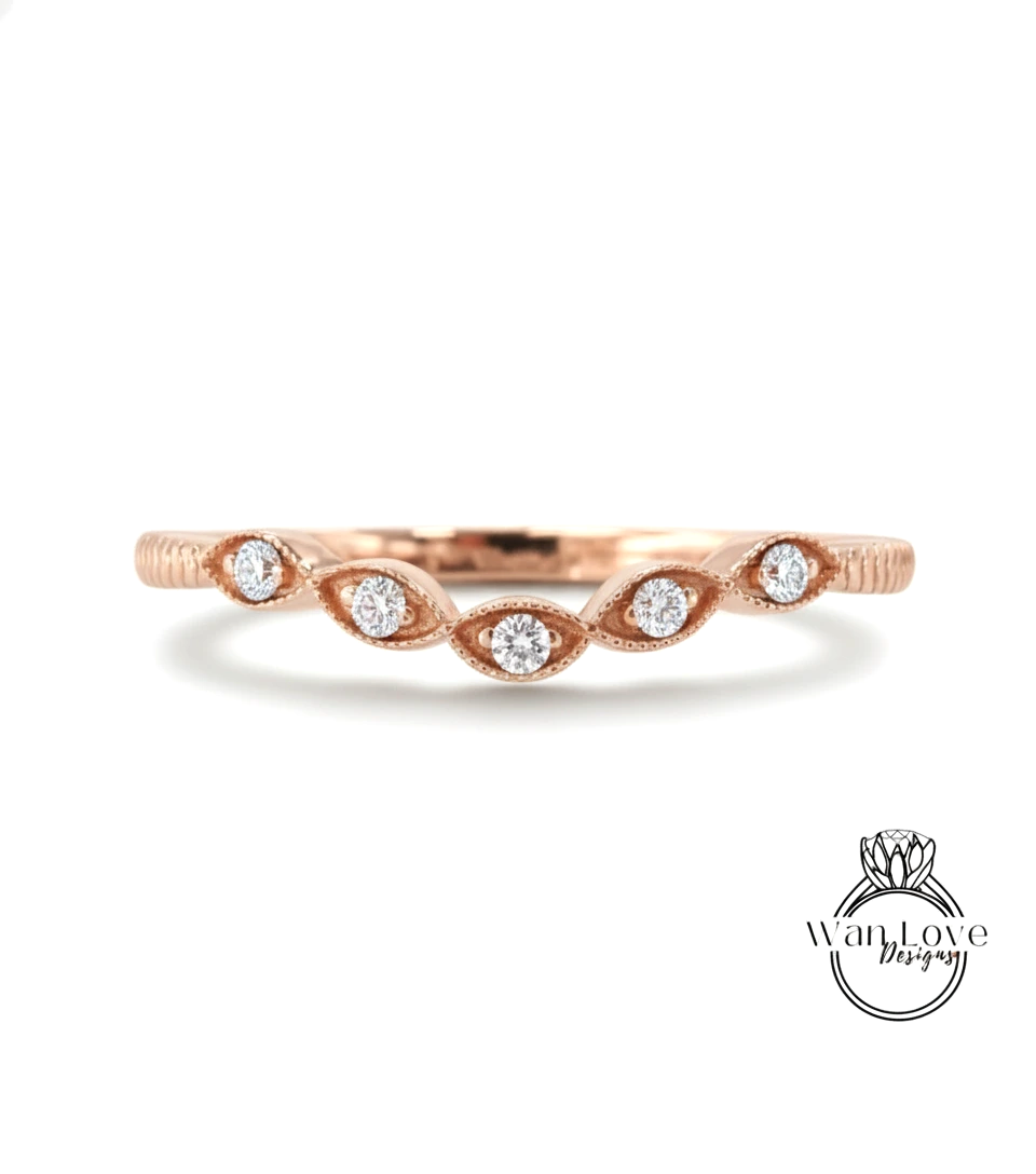 A rose gold ring with a row of small diamonds set in the center, resembling a flower or leaf design.