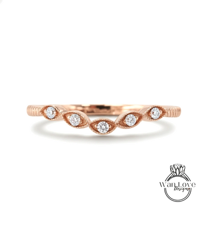 A rose gold ring with a row of small diamonds set in the center, resembling a flower or leaf design.