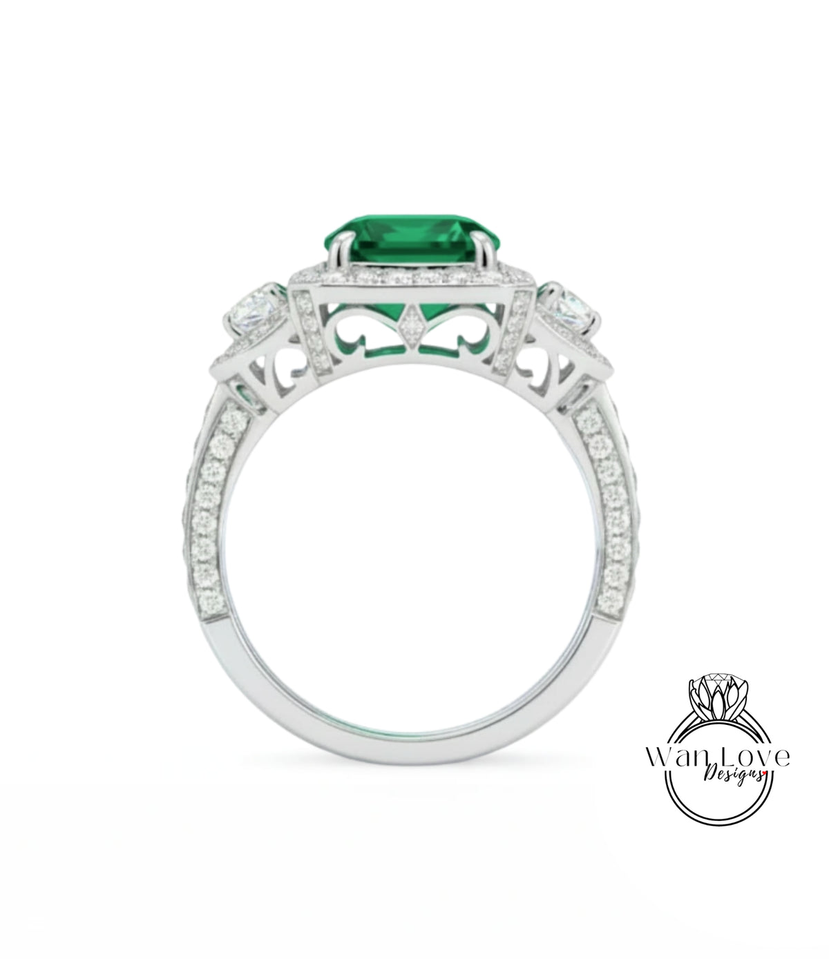 A silver ring with a large green gemstone, likely an emerald, set in a diamond-encrusted design.