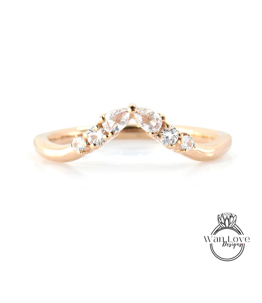 A gold ring with a diamond-encrusted band, featuring a v-shaped design with multiple small diamonds set in the center.