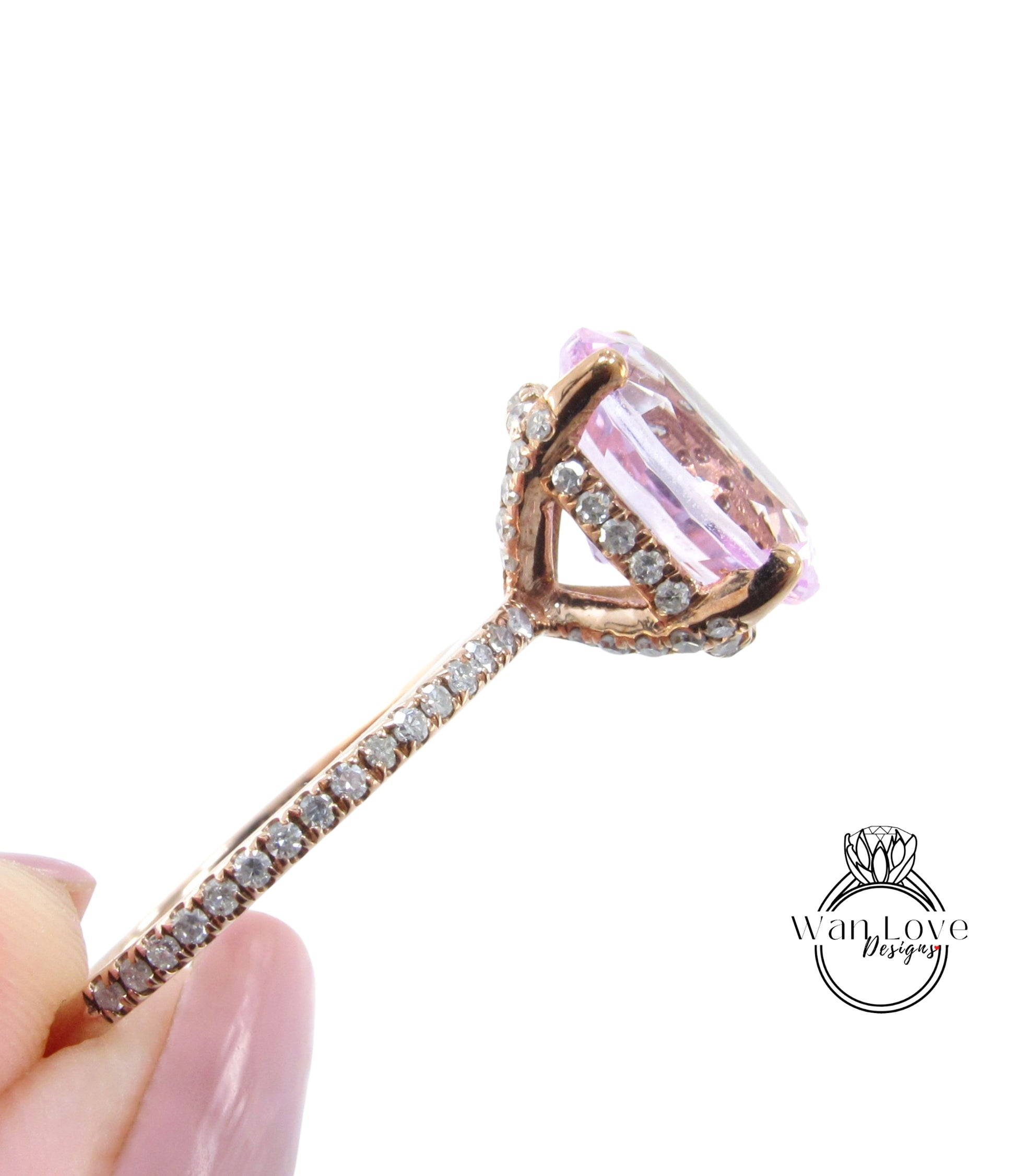 A close-up image of a gold ring with a large pink gemstone, possibly a diamond, set in the center.