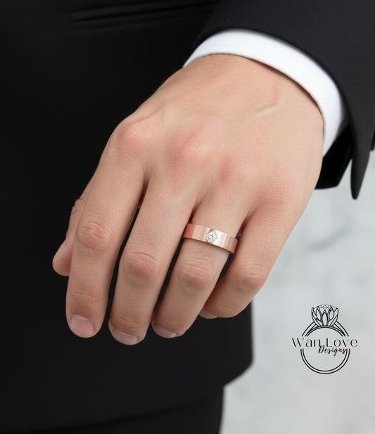 A close-up of a person's hand wearing a gold wedding ring with a diamond.