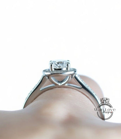 A close-up view of a silver engagement ring on a person's hand.