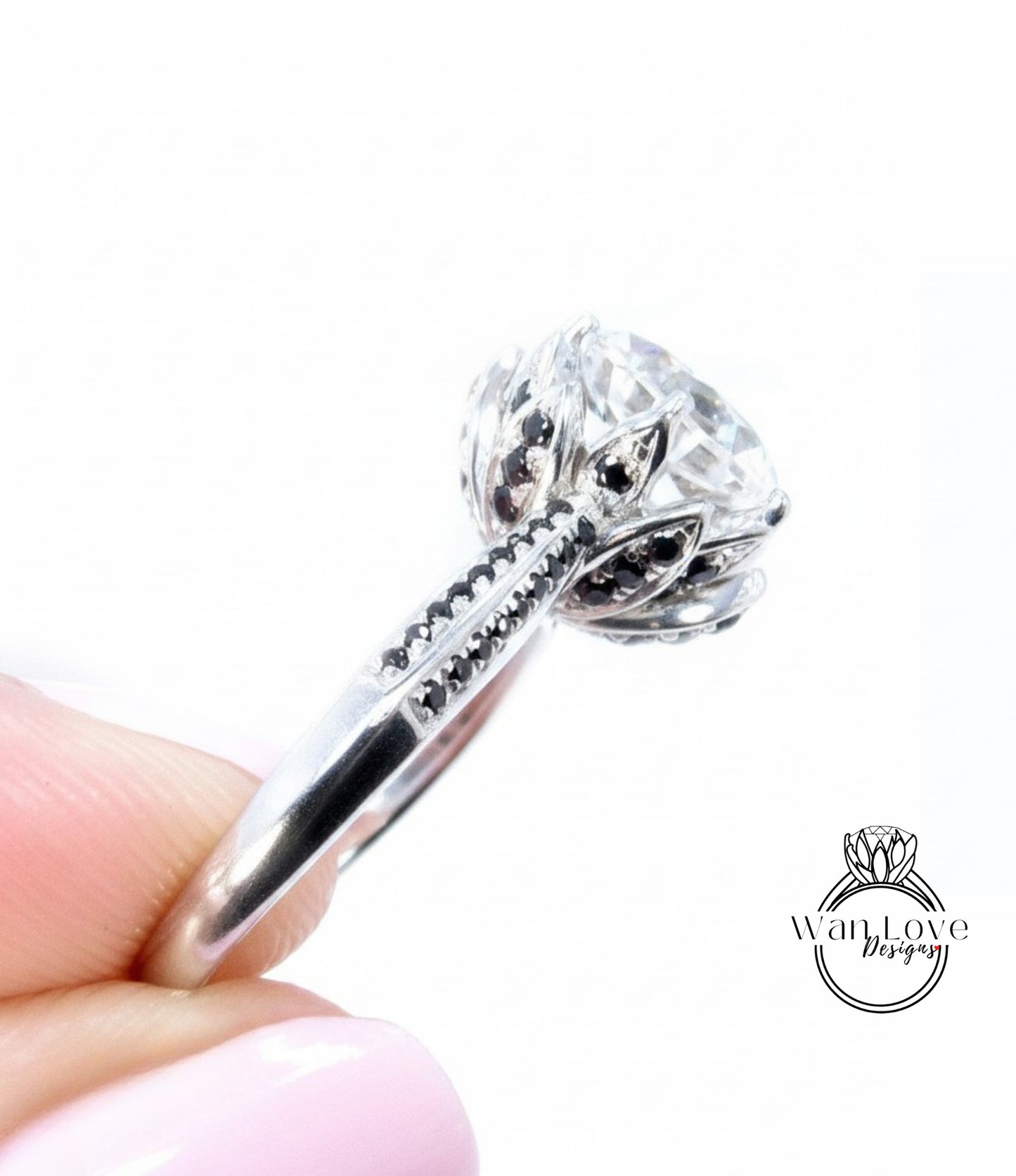 A close-up image of a person's hand holding a silver ring with a large, round diamond as the centerpiece.
